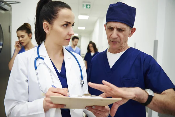 Dos Doctores Discutiendo Registros Médicos Pasillo — Foto de Stock