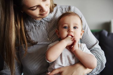 Küçük bebek kızı kucaklayan genç anne
