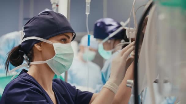 女性の麻酔医すべてのパラメータを調べる — ストック動画