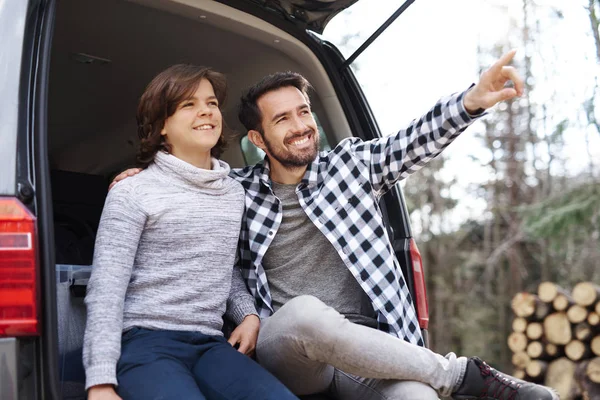 Happy father and son traveling by car