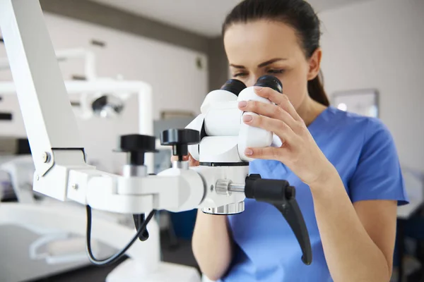 Close Dentista Feminino Olhando Através Microscópio Dentário — Fotografia de Stock