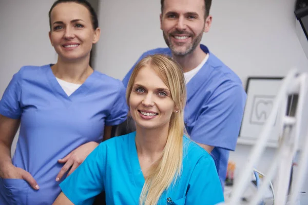 牙医办公室的微笑和满意的牙医团队 — 图库照片