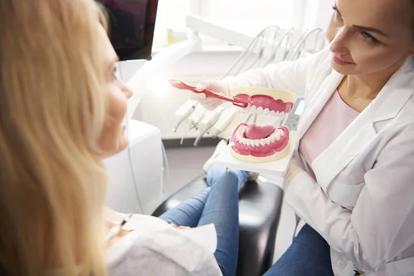 Hymyilevä Hammaslääkäri Osoittaa Oikea Tapa Harjata Hampaat — kuvapankkivalokuva