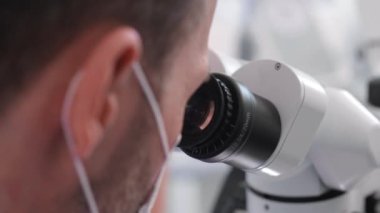 Diş mikroskobundan bakan diş hekiminin bir parçası