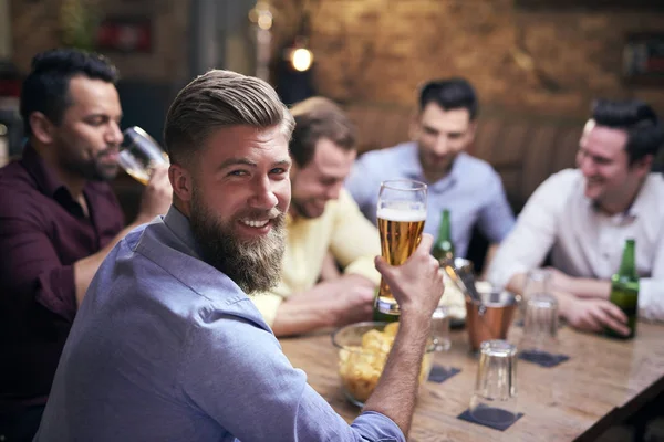 パブでビールを飲む男とバックグラウンドで友人 — ストック写真