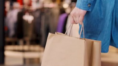 Woman's hand holding full shopping bags 