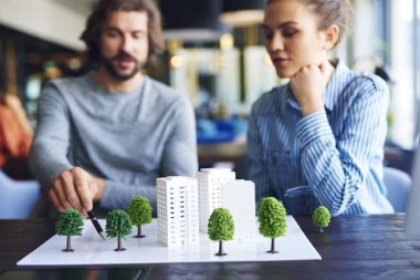 Mimari model ve arka planda genç yetişkinler mimarlar