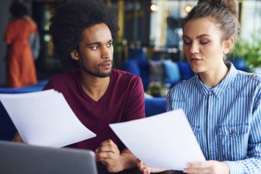 İki iş arkadaşı belgeleri analiz ediyor
