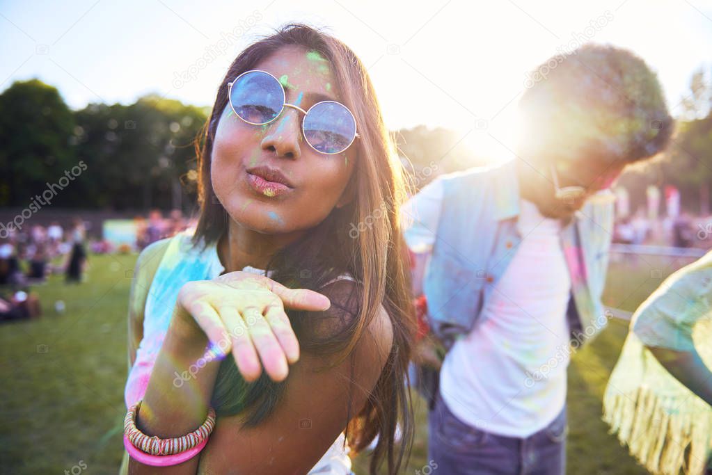 African woman blowing holi powder at the summer festival