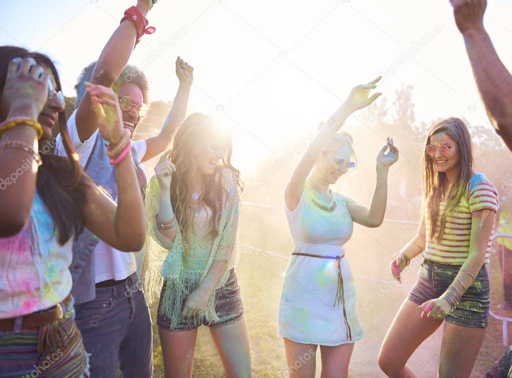 Friends in holi colors celebrating festival on fresh air