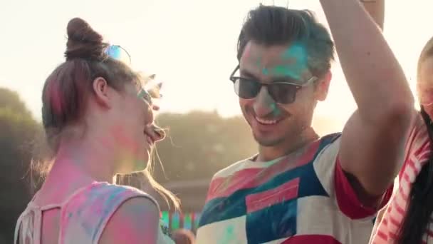 明るい太陽の光の間で踊るホーリー色のカップル — ストック動画