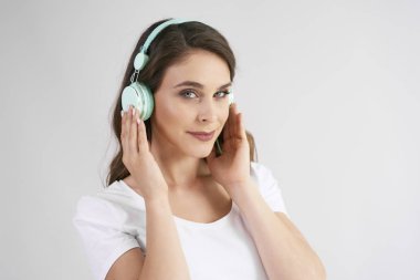 Müzik dinleyen kulaklıklı genç kadının portresi 