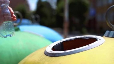 Plastik atan adam, boş şişeyi geri dönüşüm kutusuna atıyor
