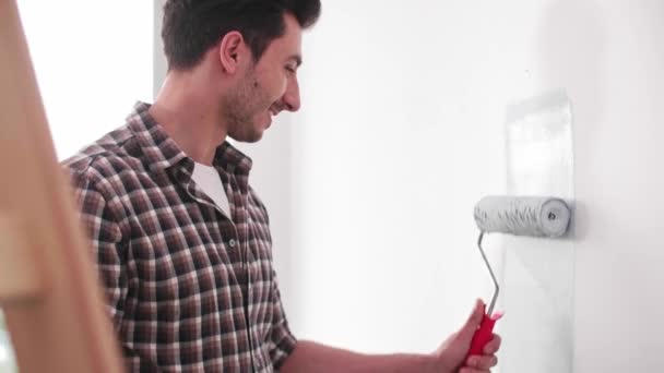 Joven Pintando Pared Interior Nuevo Apartamento — Vídeo de stock