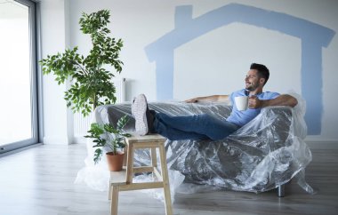 Evden kısa bir mola sırasında kahve içen genç adam 