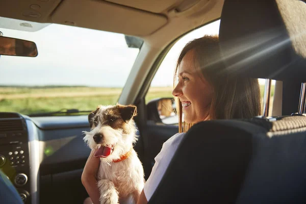 Young woman and her dog traveling together