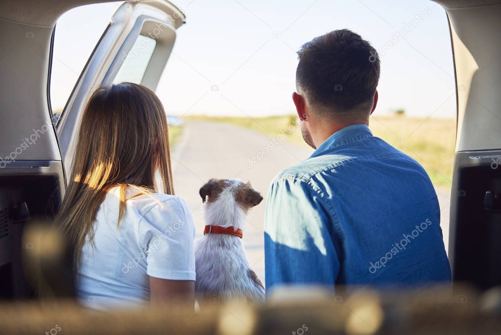 Rear view of young couple and dog enjoying the view 