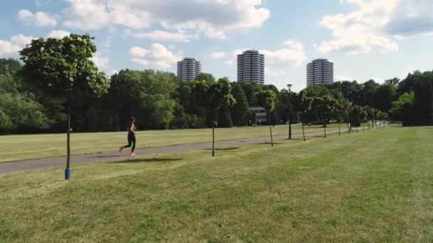 公園で走っている若い女性のドローンビュー — ストック動画