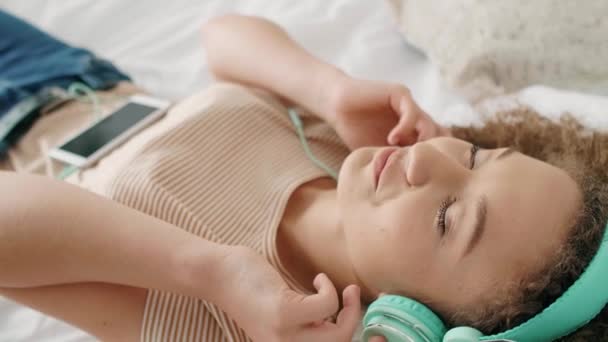 Mulher Sorridente Ouvindo Música Relaxando Cama — Vídeo de Stock