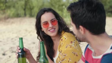 Genç çift sahilde soğuk bira içiyor