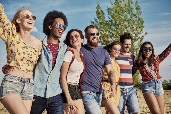 Young smiling people in a row on the fresh air 