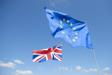 Gökyüzünün önünde Avrupa Birliği ve İngiltere bayrakları 