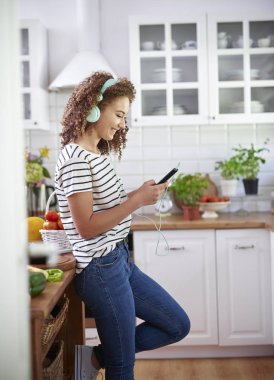Telefon ve kulaklıklı kadının yan görünümü