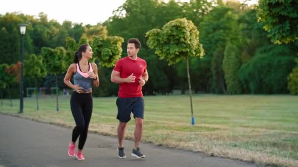 公園で一緒にジョギングする若いカップル — ストック動画
