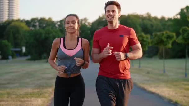 公園でジョギングをしている若いカップルの正面図 — ストック動画