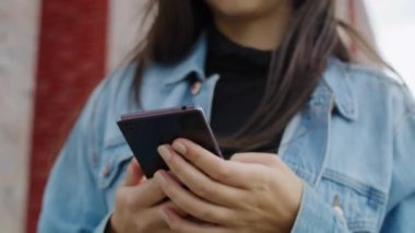 Akıllı telefon kullanan mutlu genç bir kadının videosunu kaldır. 