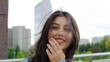 Şehirde gülümseyen genç bir kadının portresi.    