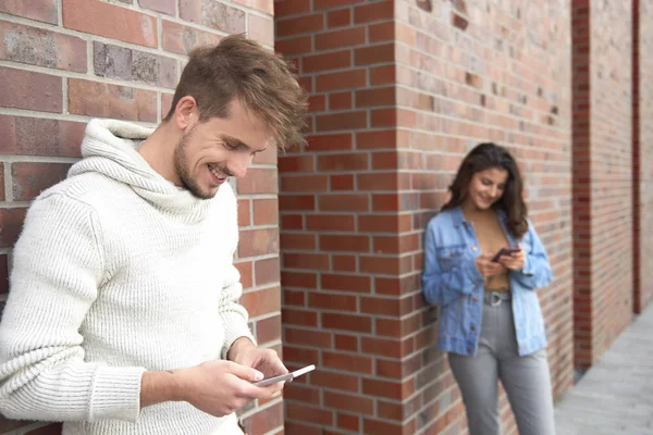 Gülümseyen Adam Arka Planda Akıllı Telefon Kadın Kullanıyor — Stok fotoğraf