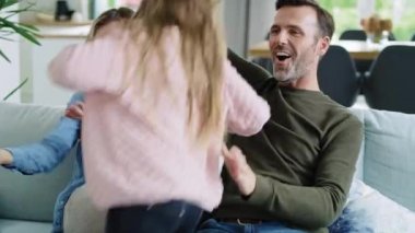 Mutlu aile birlikte oturma odasında vakit geçiriyor.