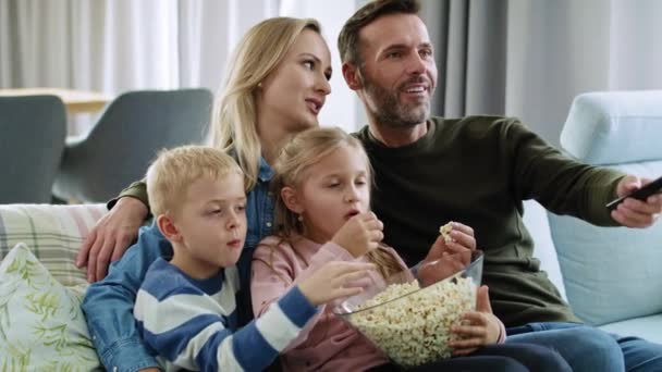 リビングでテレビを見ている2人の子供を持つ家族 — ストック動画