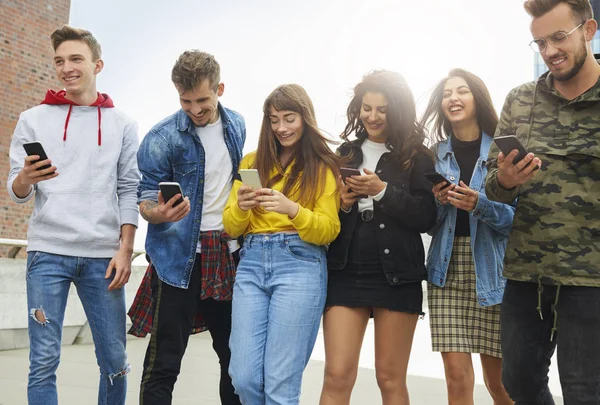 Группа Молодых Людей Смотрит Мобильный Телефон — стоковое фото