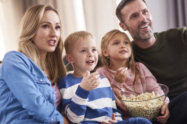 İki çocuklu aile birlikte oturma odasında vakit geçiriyorlar. 
