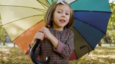 Şemsiyeli bir barınak arayan neşeli kızın el kamerası görüntüsü.