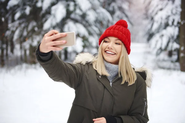 Uśmiechnięta Kobieta Robi Selfie Zimowym Lesie — Zdjęcie stockowe
