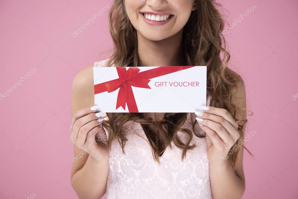 Close up of beautiful woman giving a gift voucher 