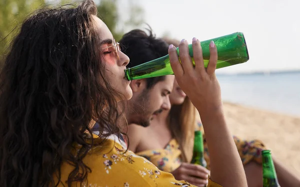 在海滩上和朋友喝啤酒的女孩的亲密接触 — 图库照片