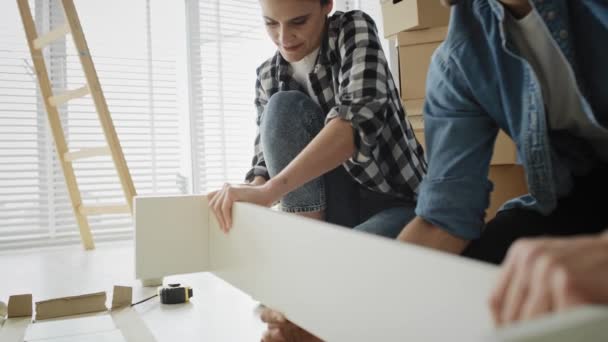 Vídeo Mano Pareja Instalando Estantería Para Casa Nueva Fotografía Con — Vídeo de stock