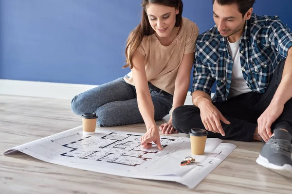 Pareja Sentada Suelo Mirando Plano Casa — Foto de Stock