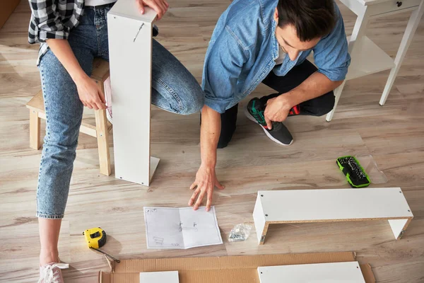 Top View Couple Using Paper Manual Furniture Installation — Stock Photo, Image