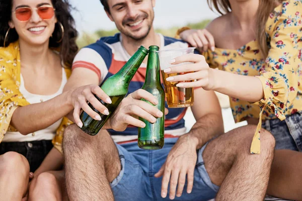 Group of friends doing celebratory toast with beer