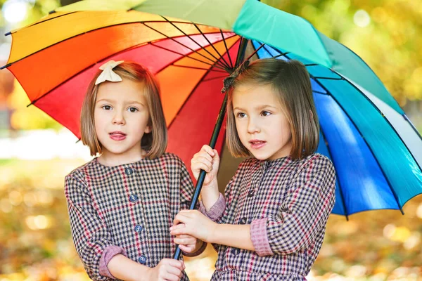 Девочки Близнецы Ищут Укрытие Зонтиком — стоковое фото