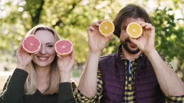 手持式看一对玩乐的夫妇享用水果 — 图库视频影像