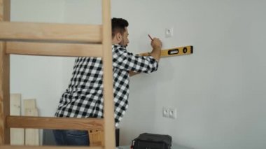 Beyaz duvardaki ruh seviyesini gösteren video takibi. 8K 'da kırmızı helyum kamerayla çekildi.
