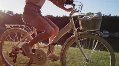 Gün batımında bisiklete binen tanınmayan birinin el kamerasıyla çekilmiş görüntüsü. 8K 'da kırmızı helyum kamerayla çekildi.. 