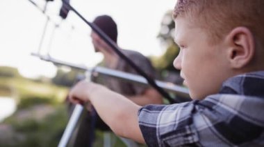 Sevecen baba ve oğulun balık tutarken çekilmiş bir videosu. 8K 'da kırmızı helyum kamerayla çekildi.