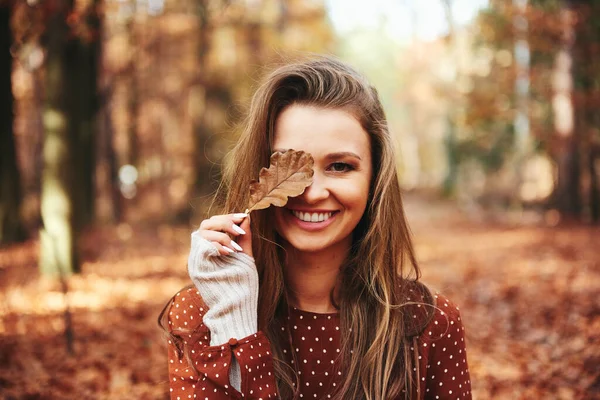 Mooie Vrouw Bedekken Oog Met Herfstbladeren — Stockfoto